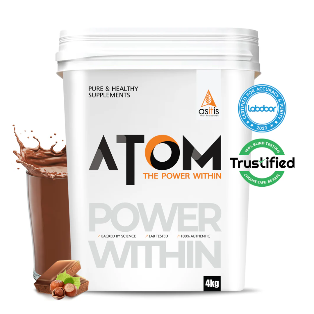 White supplement container labeled 'ATOM' with a glass of chocolate shake and cookies on a white background.
