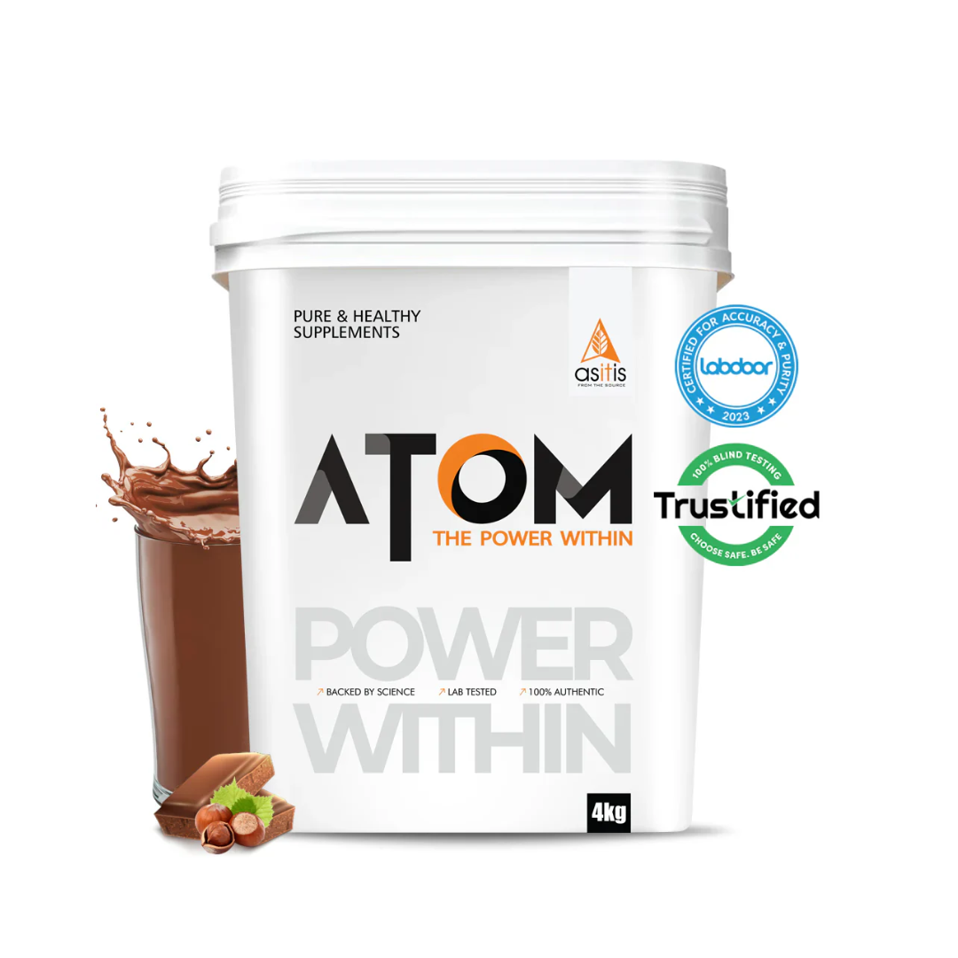 White container of Atom supplement with a glass of chocolate shake and nuts on a white background
