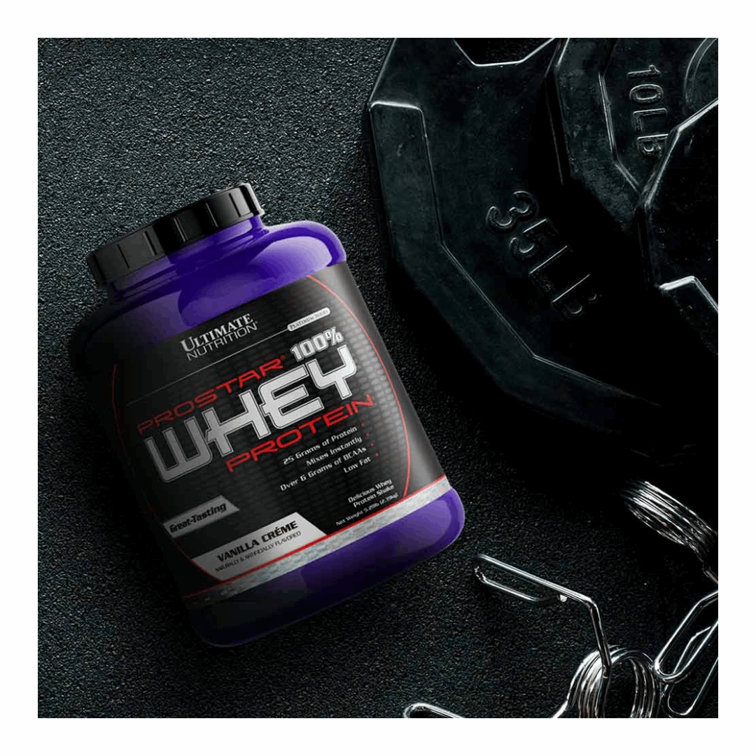 Purple protein supplement container with weights on a dark surface